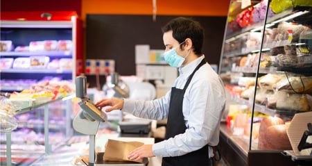 young man working at grocery deli counter