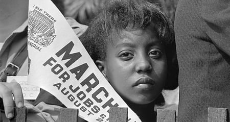 young Black girl at March on Washington holding pennant